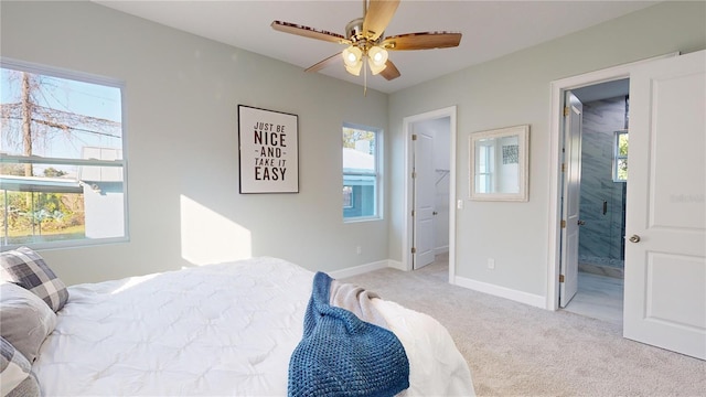 carpeted bedroom featuring ceiling fan and ensuite bath