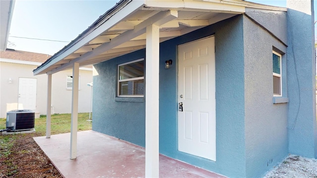 view of exterior entry featuring a patio area and cooling unit