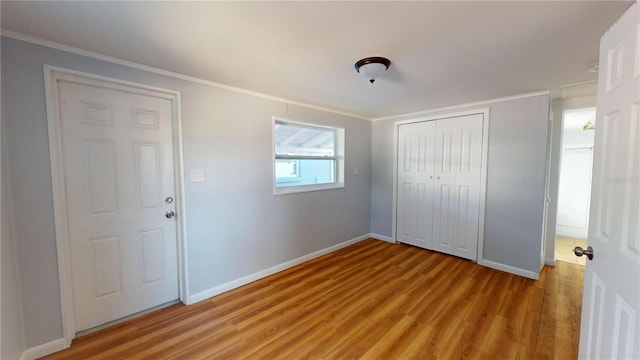 unfurnished bedroom with a closet, ornamental molding, and light hardwood / wood-style floors