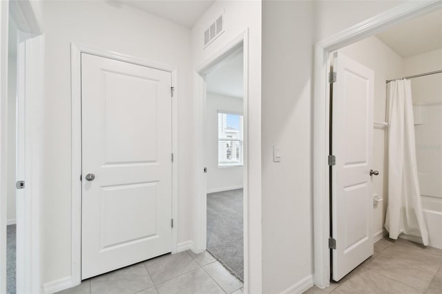 hall featuring light tile patterned floors