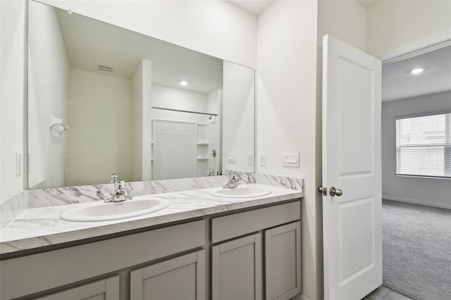 bathroom with walk in shower and vanity