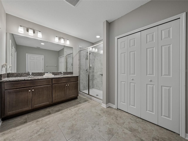 bathroom with a shower with door and vanity