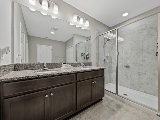 bathroom with a shower with shower door and vanity