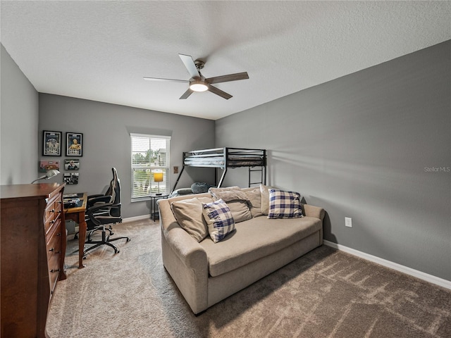 bedroom with ceiling fan, carpet floors, and a textured ceiling