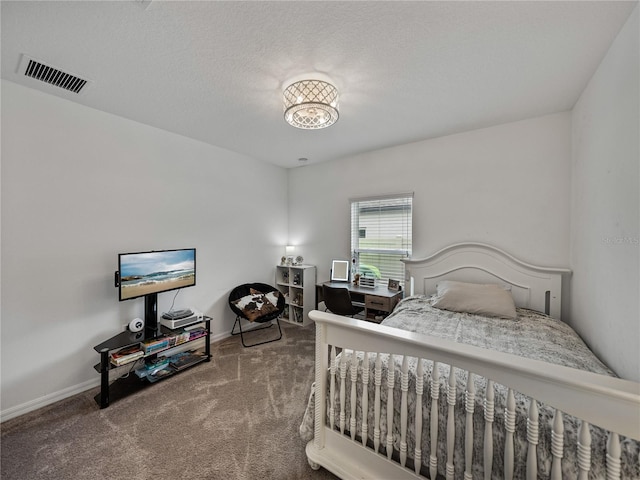 bedroom featuring carpet floors and a textured ceiling