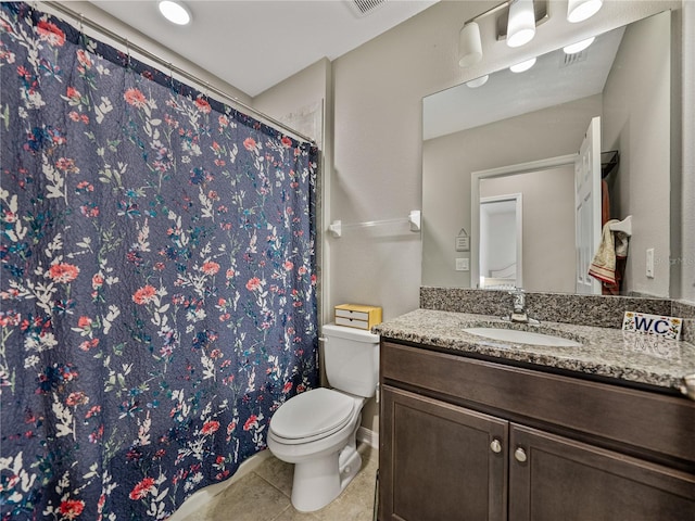 bathroom featuring toilet, vanity, and tile patterned flooring