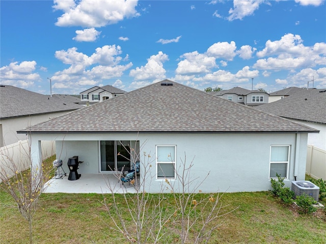 rear view of property with central AC unit, a patio, and a yard