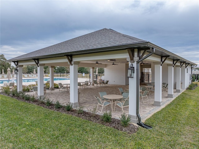 view of patio / terrace featuring ceiling fan, exterior bar, and a community pool