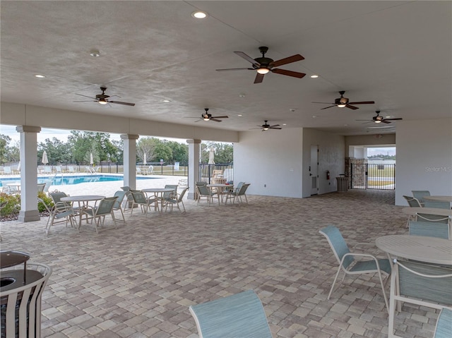 view of patio with ceiling fan and a community pool