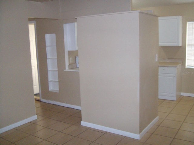 interior space featuring light tile patterned floors and white cabinetry