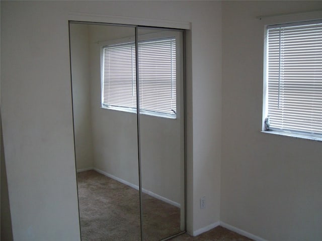 unfurnished bedroom with a closet and carpet flooring