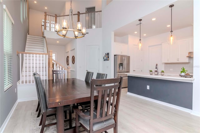 dining area with a notable chandelier and light hardwood / wood-style flooring