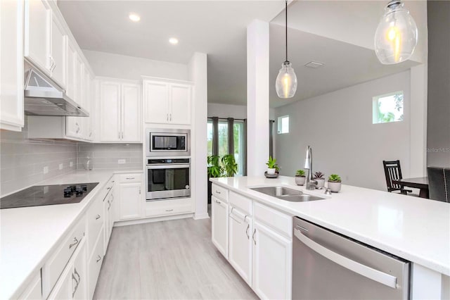 kitchen featuring sink, stainless steel appliances, white cabinets, and tasteful backsplash