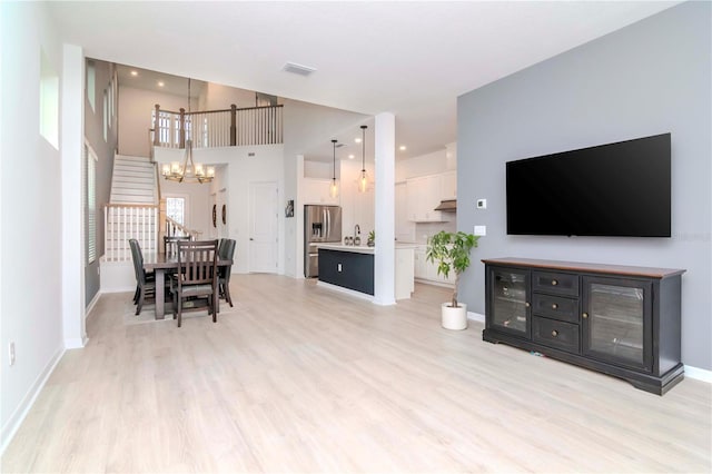 living room featuring light hardwood / wood-style floors and an inviting chandelier