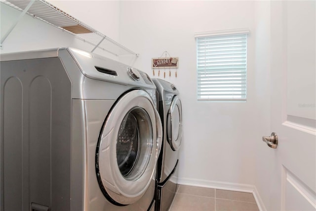 laundry room with independent washer and dryer and light tile patterned floors