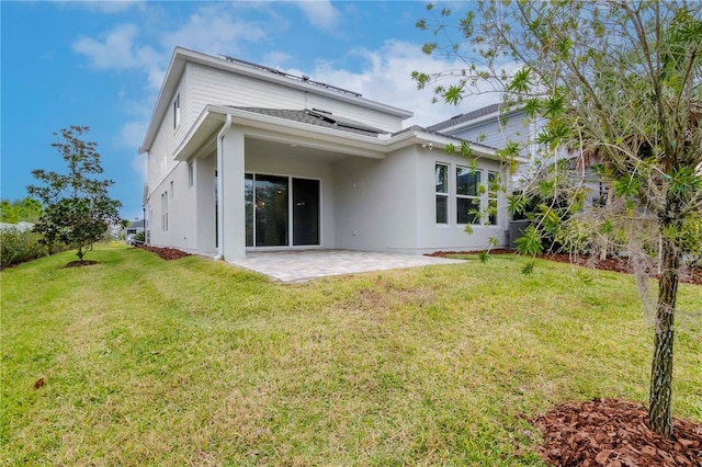 rear view of house with a patio area and a lawn