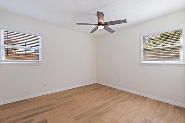 spare room featuring a wealth of natural light, ceiling fan, and light wood-type flooring