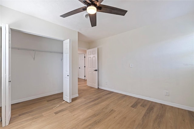 unfurnished bedroom featuring ceiling fan, a closet, and light wood-type flooring