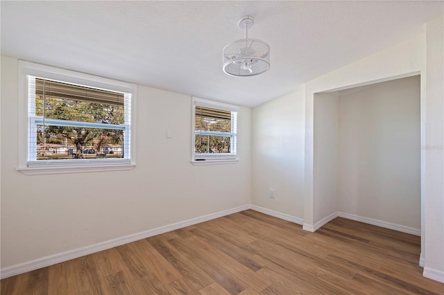 empty room with hardwood / wood-style flooring and a healthy amount of sunlight