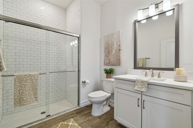 bathroom with vanity, a shower with door, and toilet