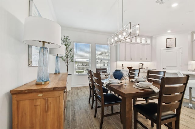 dining space featuring light hardwood / wood-style flooring and ornamental molding