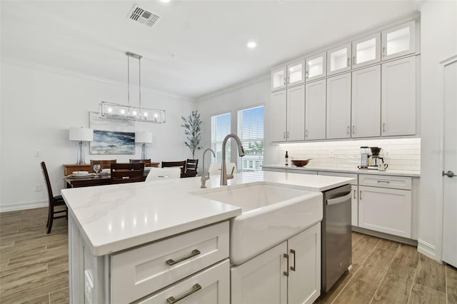 3027 Bermuda Sloop Cir, Ruskin, FL 33570 - kitchen with dishwasher, a sink, light wood-style flooring, ornamental molding, and light countertops