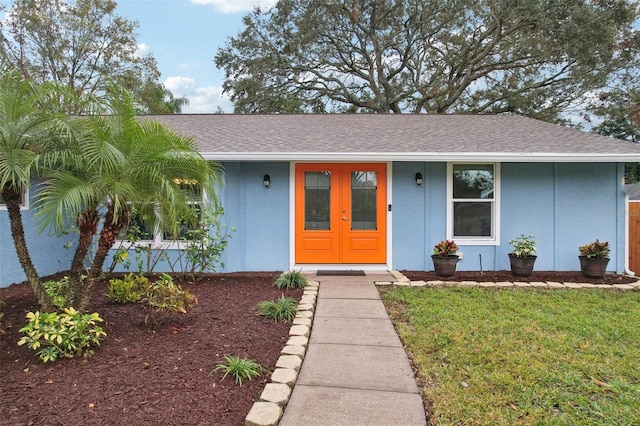 view of front of house featuring a front yard and french doors