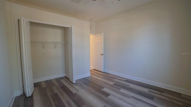 unfurnished bedroom with wood-type flooring and a closet