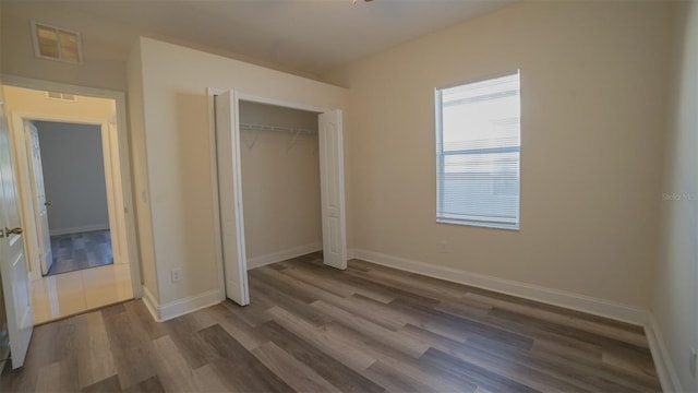 unfurnished bedroom featuring a closet and hardwood / wood-style flooring