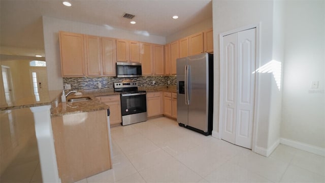 kitchen featuring light brown cabinets, appliances with stainless steel finishes, and kitchen peninsula