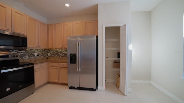 kitchen featuring tasteful backsplash, light tile patterned floors, appliances with stainless steel finishes, and light brown cabinets