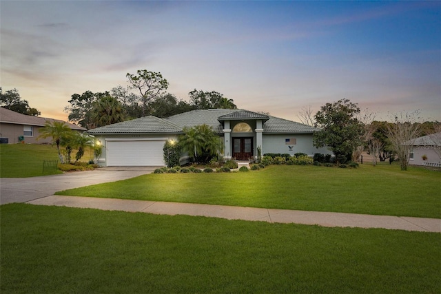 view of front of home with a garage and a yard