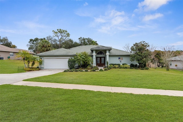 mediterranean / spanish house with a front yard and a garage