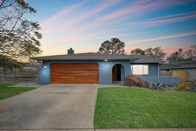 view of front of home featuring a garage and a lawn