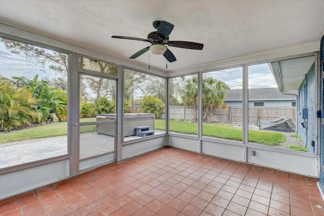 unfurnished sunroom featuring ceiling fan and a wealth of natural light