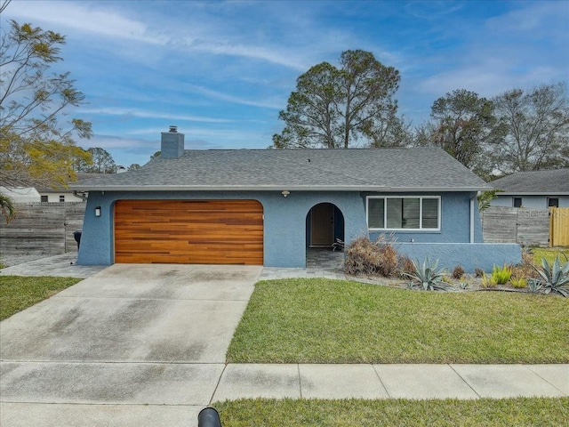 view of front of property featuring a garage and a front lawn