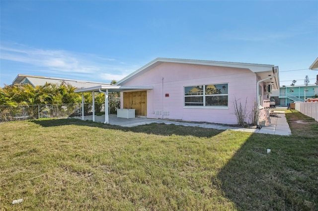 rear view of property with a patio and a lawn