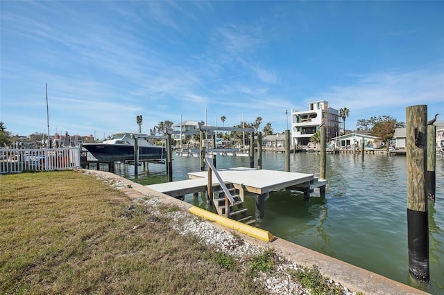 view of dock with a water view and a lawn