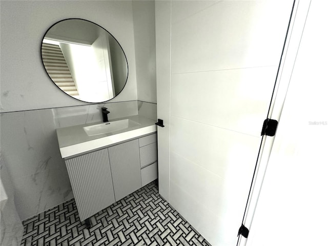 bathroom featuring vanity and tile walls