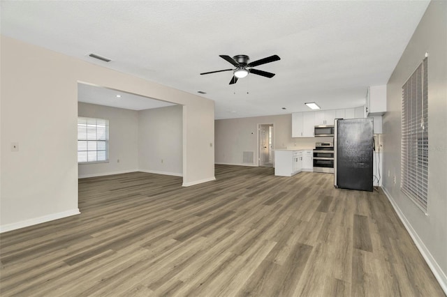 unfurnished living room with ceiling fan and light hardwood / wood-style floors