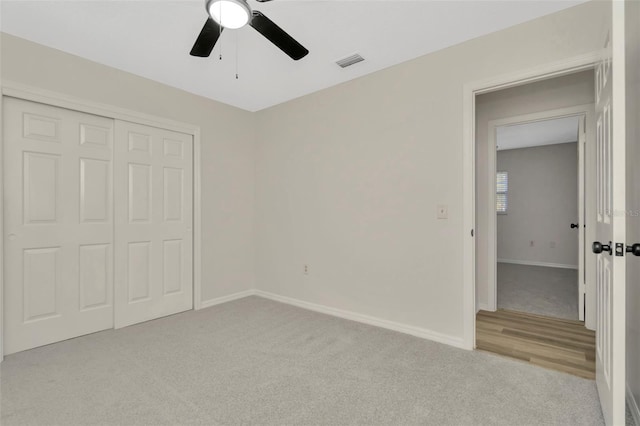 unfurnished bedroom with light carpet, ceiling fan, and a closet