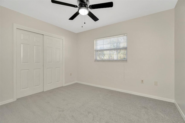 unfurnished bedroom with light carpet, a closet, and ceiling fan