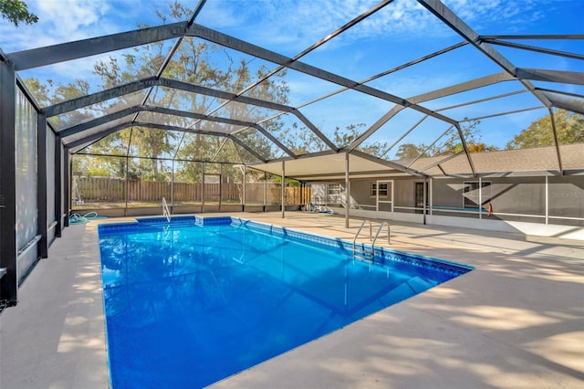 view of swimming pool featuring a patio area and glass enclosure