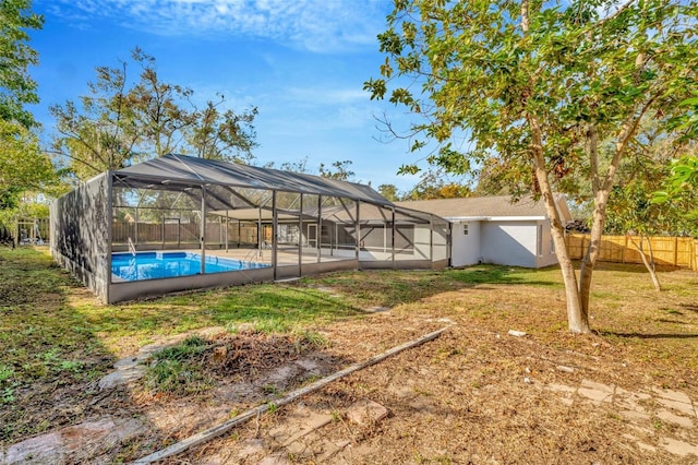 view of yard featuring a fenced in pool and glass enclosure