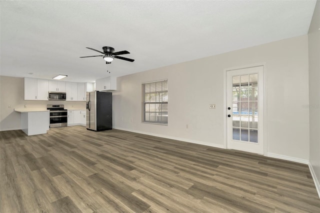 unfurnished living room with ceiling fan, hardwood / wood-style floors, and a textured ceiling