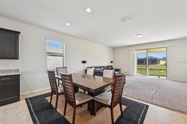 tiled dining area with a textured ceiling