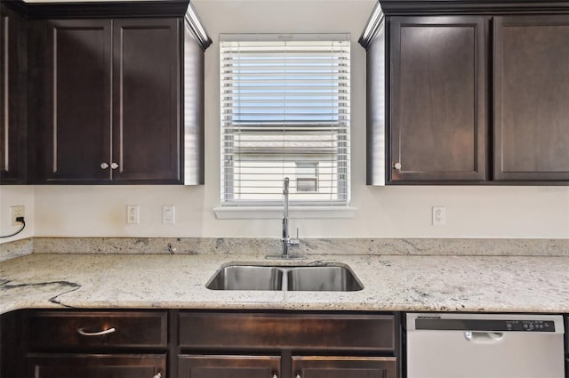 kitchen featuring dark brown cabinetry, dishwasher, sink, and light stone counters