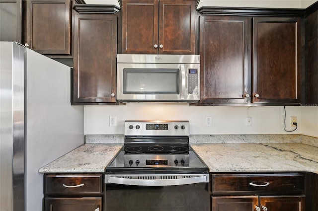 kitchen featuring stainless steel appliances, dark brown cabinets, and light stone counters