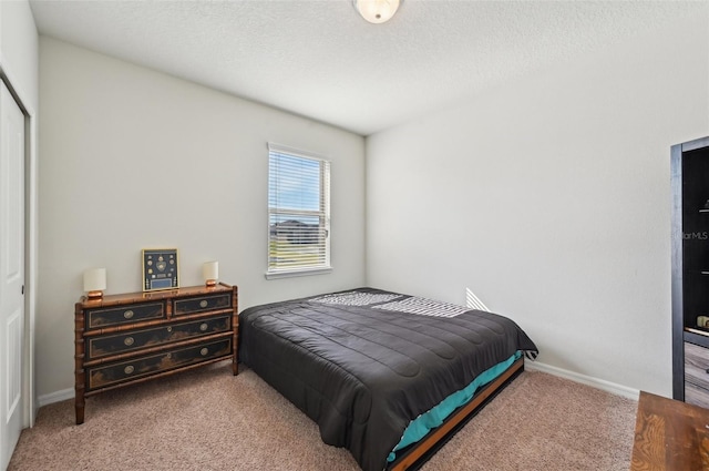 bedroom with a closet, a textured ceiling, and carpet flooring