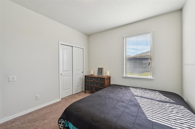 carpeted bedroom with a textured ceiling and a closet